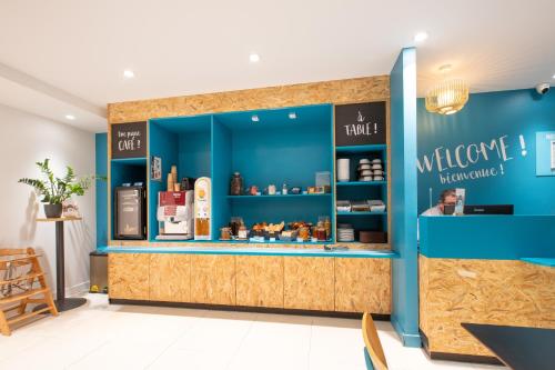 a store front with a blue wall and a counter with a counter at Kyriad Direct Nevers Nord - Varennes Vauzelles in Varennes Vauzelles