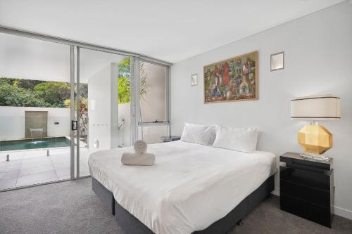 a bedroom with a large white bed and a window at Ramada By Wyndham Marcoola Beach in Marcoola