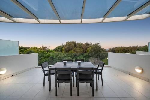 a dining room with a table and chairs at Ramada By Wyndham Marcoola Beach in Marcoola