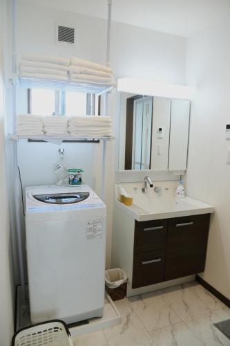a bathroom with a sink and a washing machine at 雅舍12 Osaka house new open一軒家貸切 in Osaka