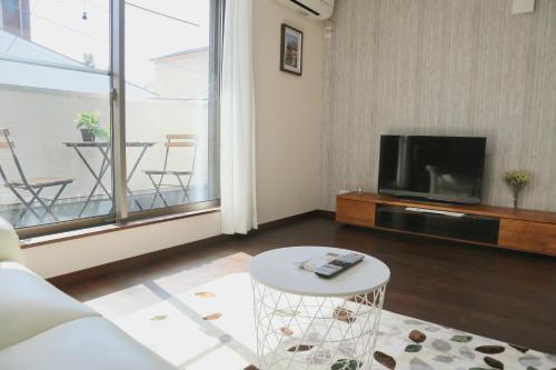 a living room with a couch and a tv and a table at 雅舍12 Osaka house new open一軒家貸切 in Osaka