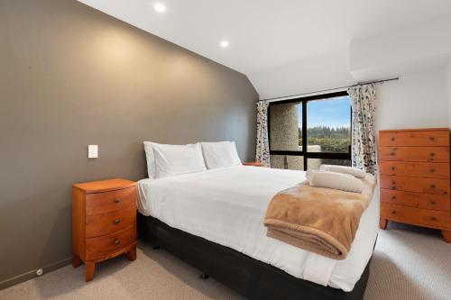a bedroom with a large bed and a window at Lodges 6 - Lake views and close to town in Queenstown