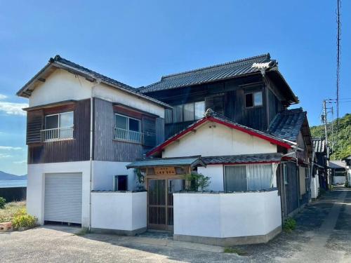 una casa in bianco e nero di 漁師宿三浦屋秀栄丸 a Shōdoshima