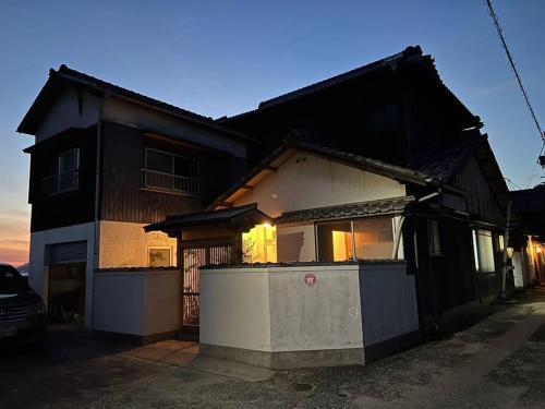 una casa con una recinzione di fronte di 漁師宿三浦屋秀栄丸 a Shōdoshima