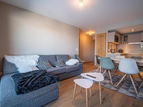 un salon avec un canapé et des chaises et une cuisine dans l'établissement Appartement neuf 6 pers, pied de pistes avec parking, Valmorel - FR-1-356-521, à Valmorel