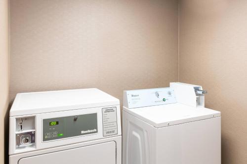 a laundry room with a refrigerator and a washing machine at Courtyard by Marriott Bloomington in Bloomington