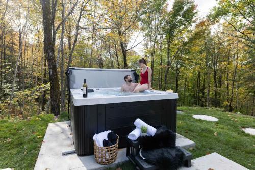 a man and a woman in a bath tub at Mini chalet Ecohaven - SPA in Brownsburg