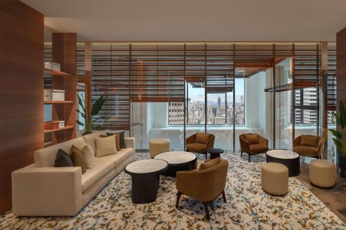 a living room with a couch and tables and chairs at W Taipei in Taipei