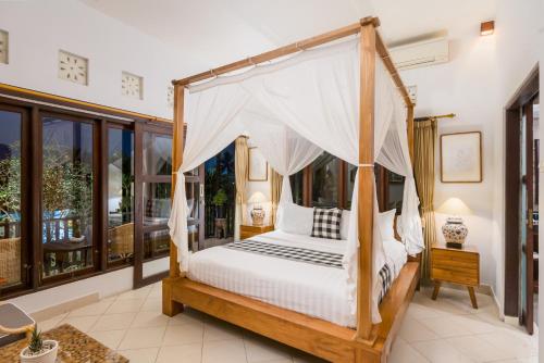 ウブドにあるUmah Bali Villaのベッドルーム1室(天蓋付きベッド1台付)
