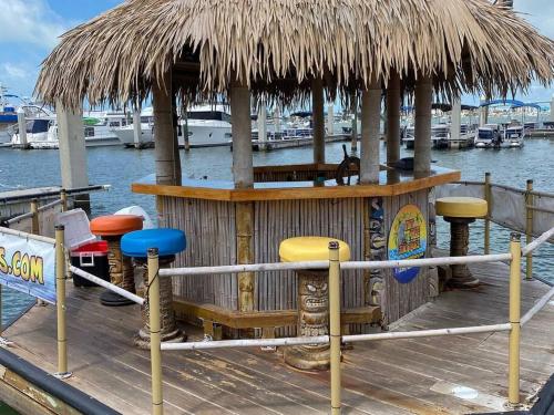 a cabin with a straw roof on a dock at DOWNTOWN 3rd Street Retreat Lookout in Fort Myers Beach