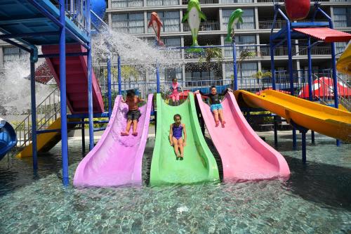 a group of children playing on a water slide at a water park at Anantara Vacation Club Mai Khao Phuket in Mai Khao Beach