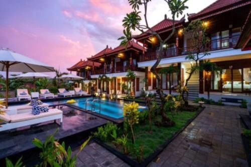 a villa with a swimming pool and a house at Lembongan Cempaka Villa & Restaurant in Nusa Lembongan