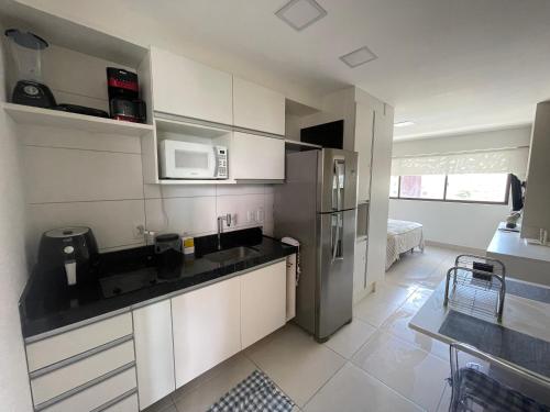 a kitchen with white cabinets and a stainless steel refrigerator at Flat Prime BC Ilha do Leite in Recife