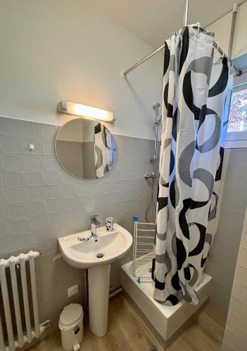 une salle de bain avec un lavabo et un rideau de douche dans l'établissement Studio en rez de jardin DEAUVILLE CENTRE et Plage, à Deauville