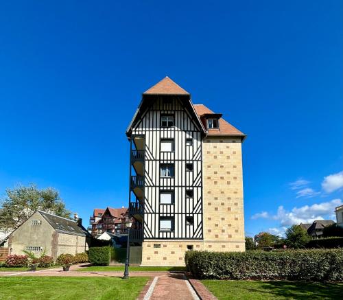 un bâtiment noir et blanc avec une tour dans l'établissement Studio en rez de jardin DEAUVILLE CENTRE et Plage, à Deauville