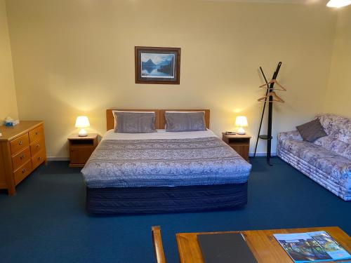 a bedroom with a bed and a couch at Willowbrook Country Apartments in Arrowtown