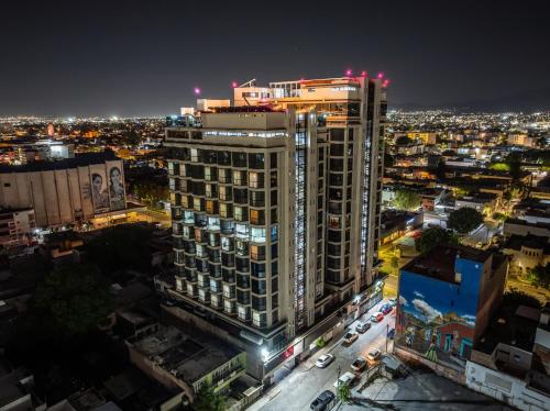 a tall building in a city at night at Hotel Real Plaza in San Luis Potosí