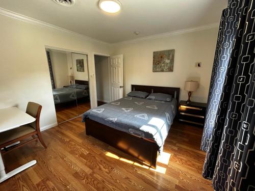a bedroom with a bed and a table and a mirror at 洛杉矶东部花园式独立屋三室两卫 in El Monte