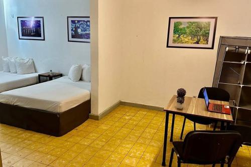 a room with two beds and a table and a desk at Depa Familiar a 2 cuadras del Auditorio Benito Juárez in Veracruz