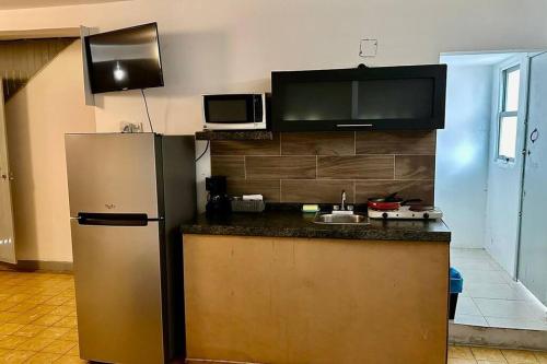 a kitchen with a refrigerator and a microwave at Depa Familiar a 2 cuadras del Auditorio Benito Juárez in Veracruz