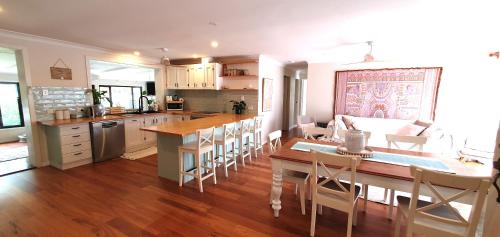 a kitchen and dining room with a table and chairs at Gold Coast Family Retreat, beach 1 and half kms, shops, full home in Gold Coast