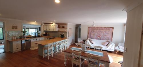 a kitchen and living room with a table and a couch at Gold Coast Family Retreat, beach 1 and half kms, shops, full home in Gold Coast