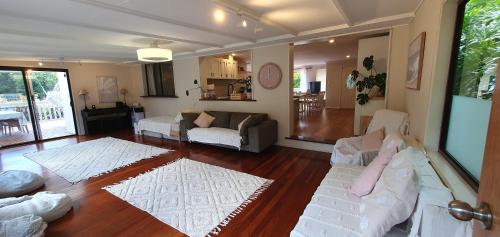 a living room with two white couches and a couch at Gold Coast Family Retreat, beach 1 and half kms, shops, full home in Gold Coast