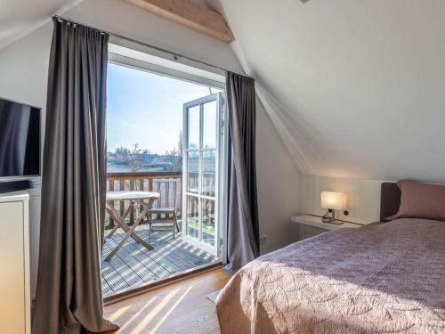 a bedroom with a bed and a balcony with a view at Premium Ferienhaus Söss Diek in Groß Schwansee in Kalkhorst