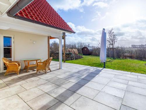 a patio with a table and chairs and an umbrella at Premium Ferienhaus Söss Diek in Groß Schwansee in Kalkhorst
