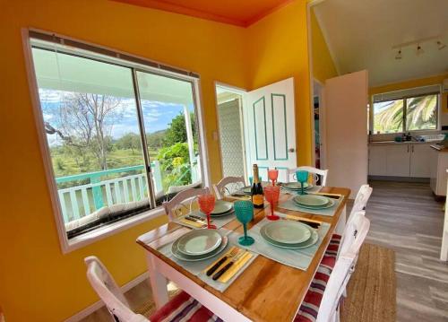 a dining room with a table and a large window at Lowood Riverelle Cottage in Lowood