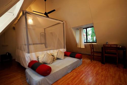 a bedroom with a bed with a canopy at Temple Garden Palolem in Canacona