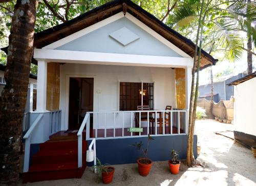 a small house with a blue and white facade at Temple Garden Palolem in Canacona