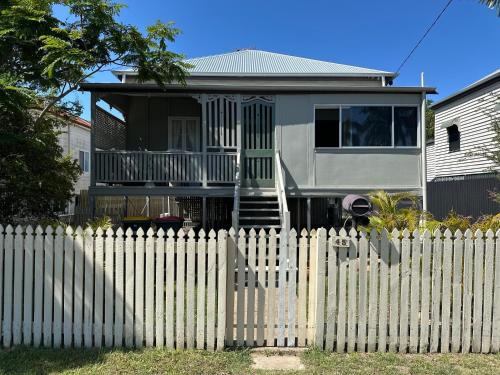 a house behind a white picket fence at House On Kent Whole House in Rockhampton
