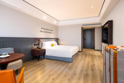 Uma cama ou camas num quarto em Echarm Hotel Haikou Friendship Sunshine City Qiaozhong Road Branch