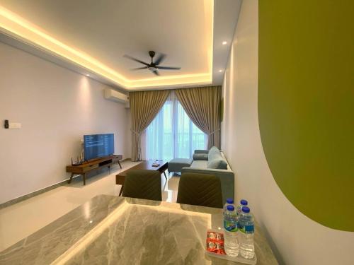 a living room with a couch and a table with water bottles at R&F Princess Cove JB Apartment Suites By SC Homestay in Johor Bahru