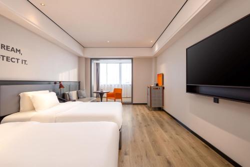 Uma televisão e/ou sistema de entretenimento em Echarm Hotel Haikou Friendship Sunshine City Qiaozhong Road Branch