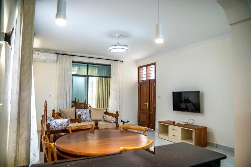 a living room with a table and a couch at Leshan Luxury Villas in Diani Beach