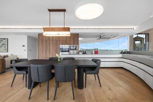 a kitchen and dining room with a black table and chairs at 3 Bedroom Darling Harbour Apartment in Sydney