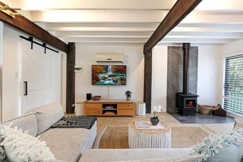 a living room with a couch and a fireplace at Serenity 222 The Estate in Jervis Bay in St Georges Basin