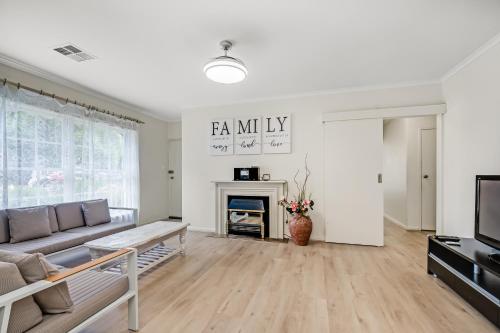 a living room with a couch and a fireplace at Jetty Road Retreat - Brighton - C21 SouthCoast Holidays in Brighton