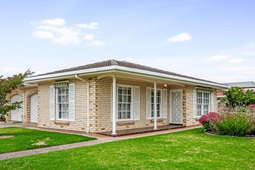 a house with a green lawn in front of it at Jetty Road Retreat - Brighton - C21 SouthCoast Holidays in Brighton