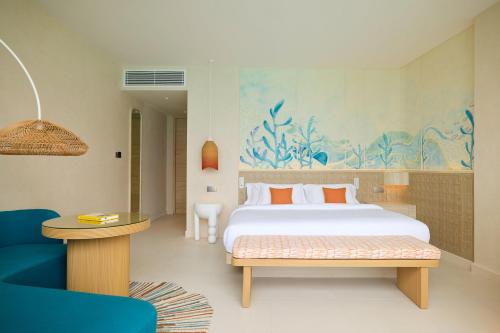 a bedroom with a bed and a blue painting on the wall at Centara Mirage Lagoon Maldives in Nakachchafushi