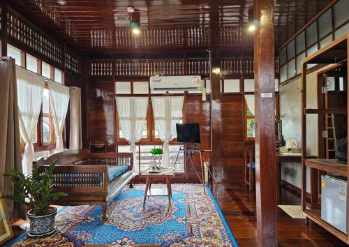 a living room with a couch and a television at Bannai Bangkoknoi บ้านในบางกอกน้อย in Ban Bang Bamru