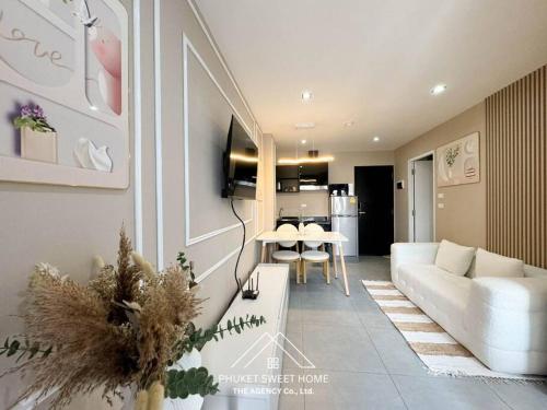 a living room with a couch and a table at Tower condo Rawai Phuket in Ban Klang