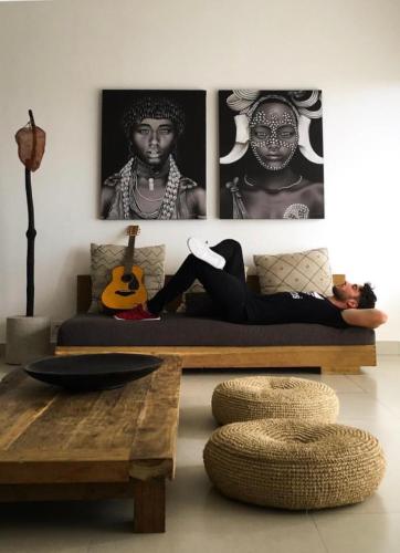 a woman sitting on a couch in a living room at TheSoulHouseBali in Canggu