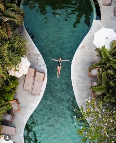 a woman in a swimsuit swimming in a pool at TheSoulHouseBali in Canggu