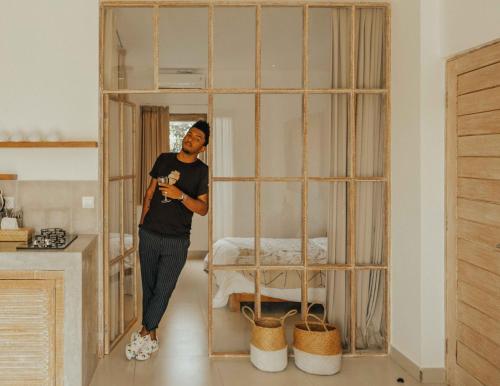 a woman standing in front of a room with a gate at TheSoulHouseBali in Canggu