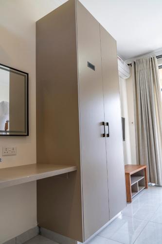 a large white cabinet in a room with a mirror at Leshan Luxury Villas in Diani Beach