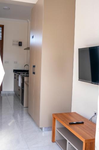 a kitchen with a table and a tv on a wall at Leshan Luxury Villas in Diani Beach
