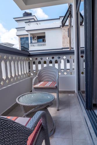 a balcony with a table and chairs and a building at Leshan Luxury Villas in Diani Beach